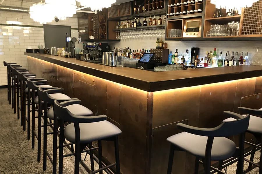 Bespoke bronze bar joinery with integrated lighting, manufactured and installed by JPS Services